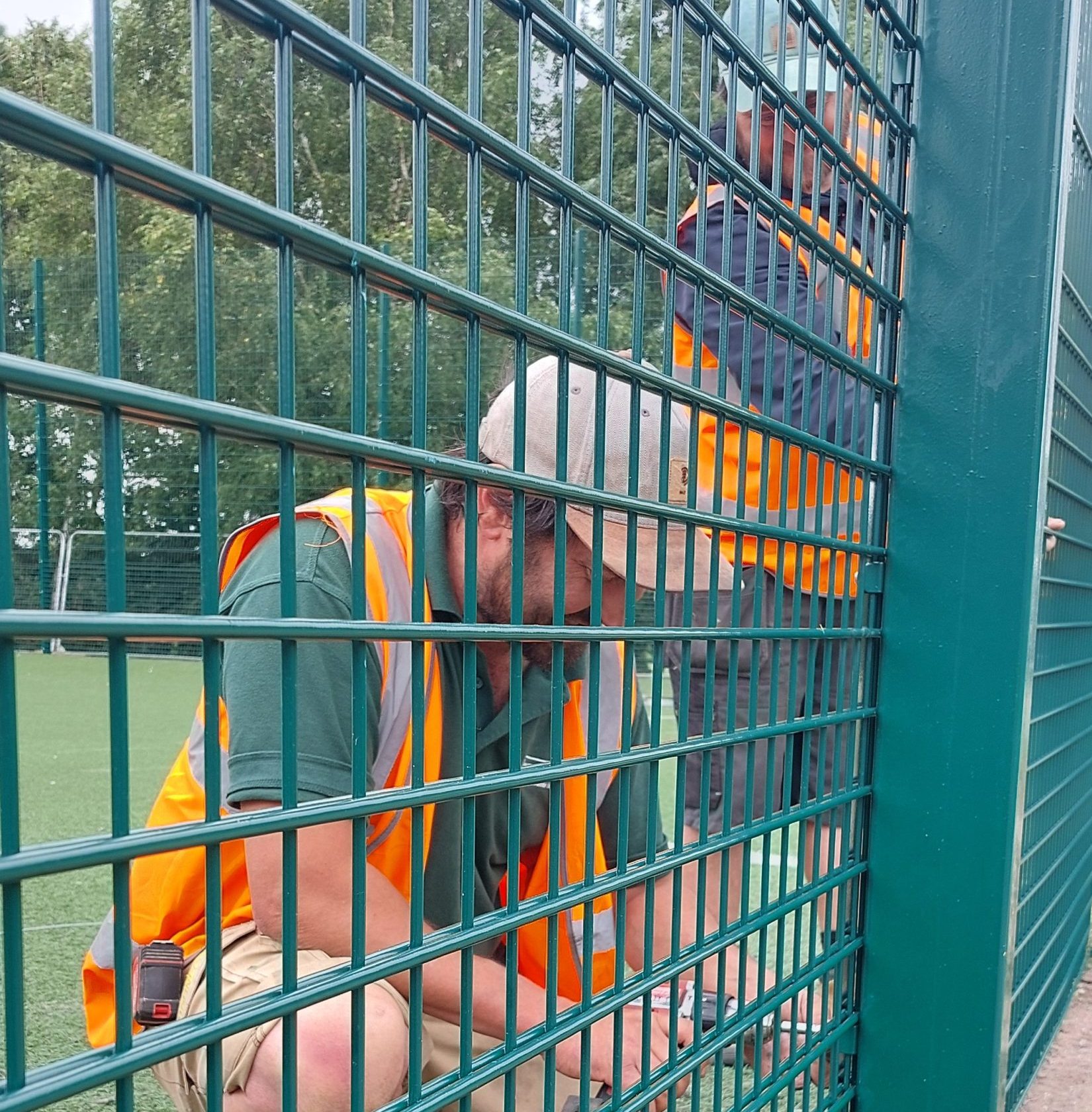 UK contractor securing industrial security fencing with hand tools