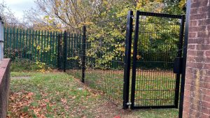 A pedestrian gate with black security mesh