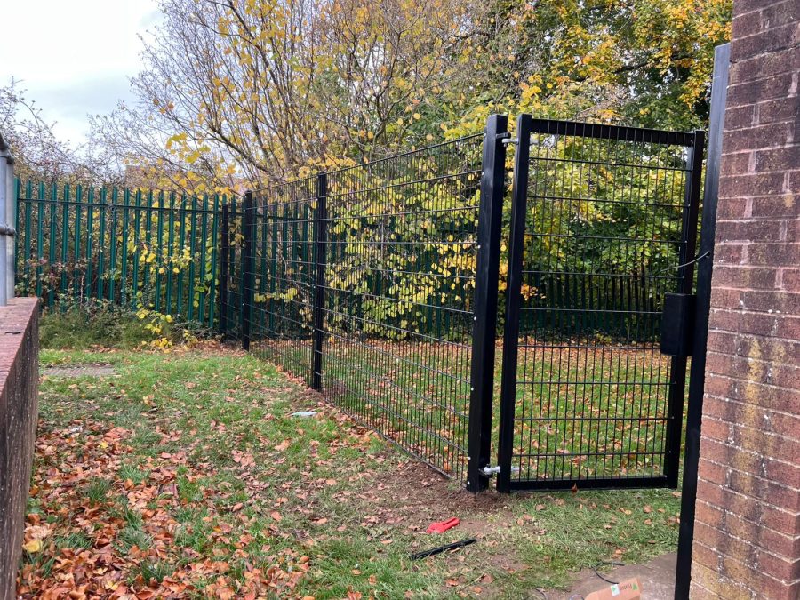 A pedestrian gate with black security mesh