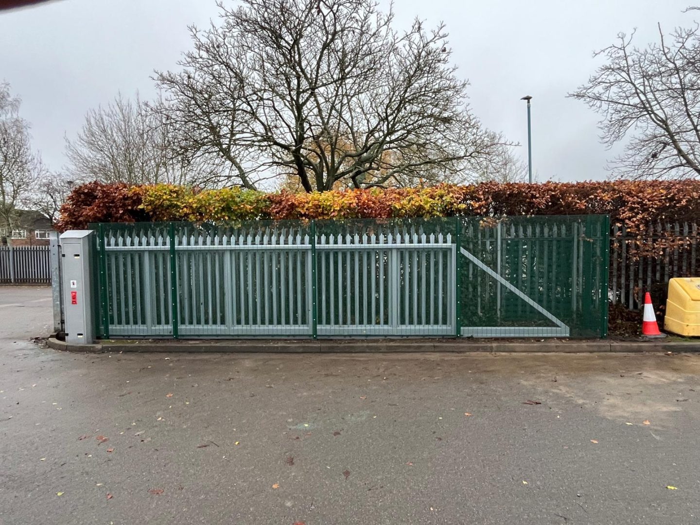 steel mesh with small holes in around a sliding auto gate. These enclosure are designed to prevent accidents where children or staff get too close to moving parts of the auto gate