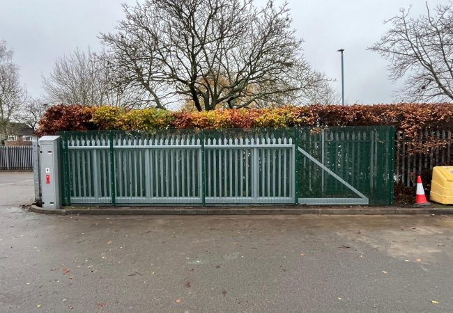steel mesh with small holes in around a sliding auto gate. These enclosure are designed to prevent accidents where children or staff get too close to moving parts of the auto gate