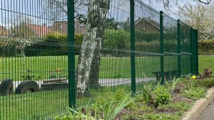 Green mesh fence around a school playing field