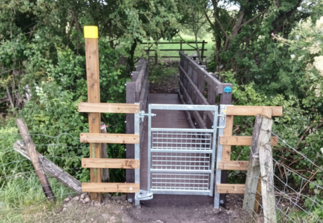 A steel gate in front of a newly installed pedestrian bridge in Chesterton, Warks