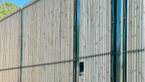 Vision stopping mesh fence with timber slats in