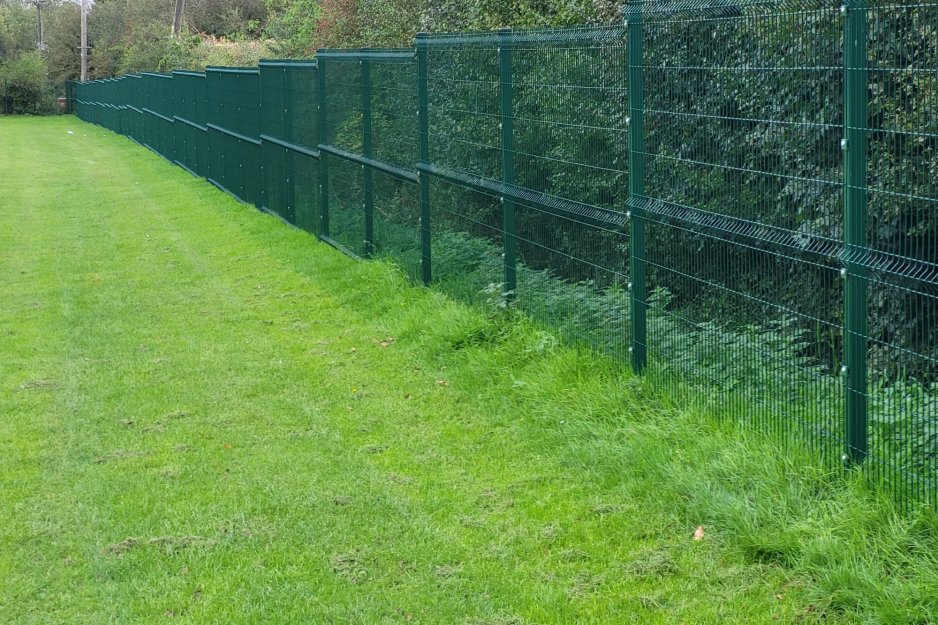 Mesh fencing around playing field perimeter